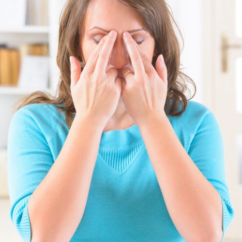 Woman doing EFT on the eye brow point. Emotional Freedom Techniques, tapping, a form of counseling intervention that draws on various theories of alternative medicine.